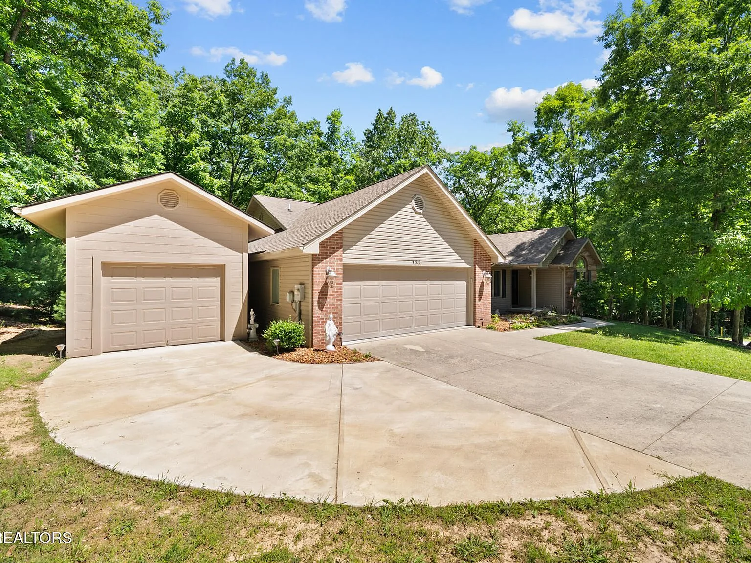 Two-car garage frontage framed by mature trees